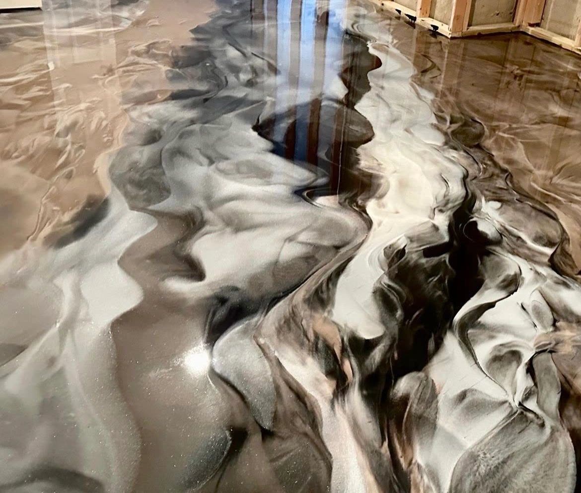 After: black and gold metallic epoxy swirl finish in the same basement