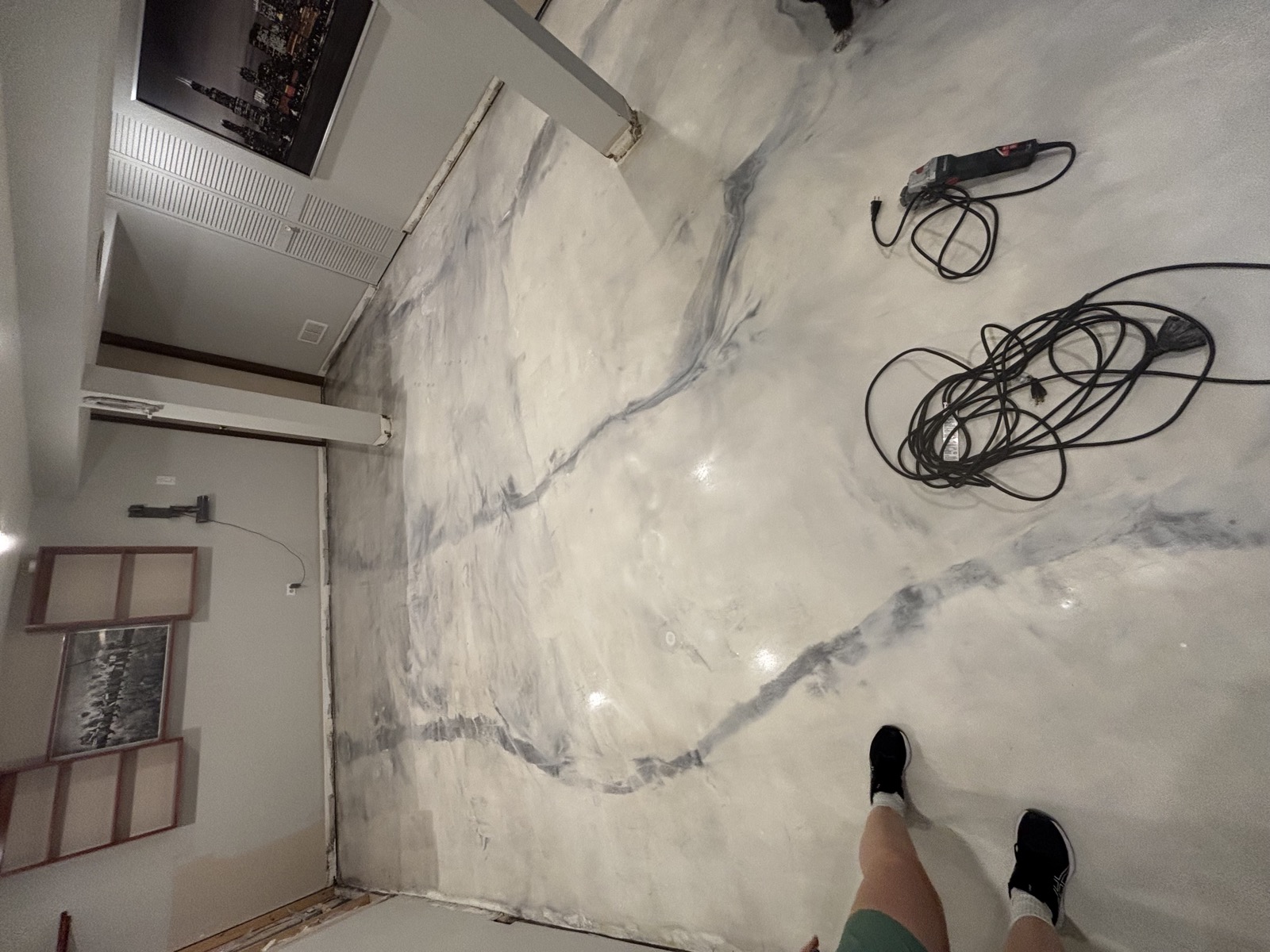 Marble-effect metallic epoxy basecoat mid-application in a basement